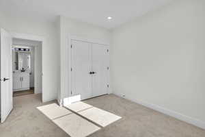 Bedroom 2 featuring recessed lighting, a closet, baseboards, and light carpet