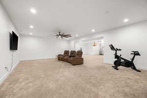 Interior space featuring ceiling fan with notable chandelier and light carpet