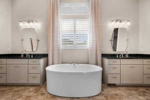 Bathroom featuring vanity and a tub to relax in