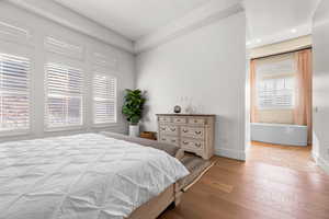 Bedroom with multiple windows and light hardwood / wood-style flooring