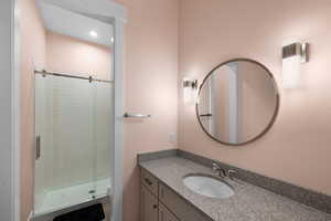 Bathroom with vanity, toilet, and an enclosed shower