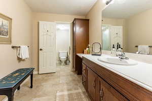 Bathroom with tile patterned floors, vanity, a textured ceiling, and toilet