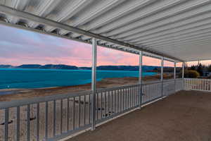 Balcony at dusk featuring a water and mountain view