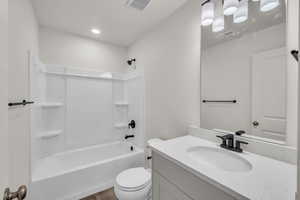 Full bathroom with vanity, tub / shower combination, toilet, and hardwood / wood-style floors