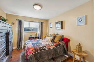 Bedroom with dark hardwood / wood-style floors