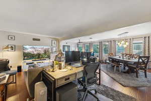 Office area featuring dark wood-type flooring and a chandelier