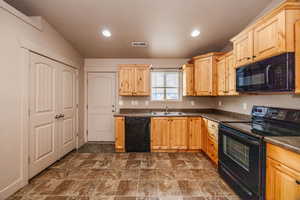 Kitchen featuring sink, black appliances, and light brown cabinets