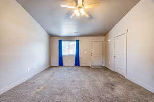 Carpeted living room featuring ceiling fan, a textured ceiling, and vaulted ceiling