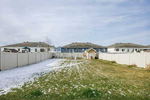 Back of house featuring a yard and a shed