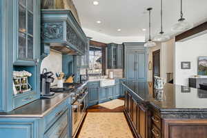 Kitchen featuring decorative backsplash, sink, decorative light fixtures, and range with two ovens