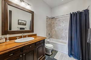 Full bathroom featuring tile patterned floors, vanity, shower / bath combo, and toilet