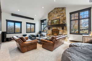 Living room featuring plenty of natural light, light colored carpet, and lofted ceiling