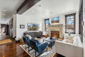 Living room featuring dark hardwood / wood-style floors and a stone fireplace