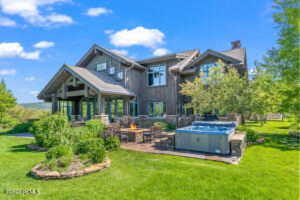 Back of house featuring a lawn and a hot tub