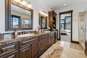 Bathroom featuring tile patterned floors, vanity, and a shower with door