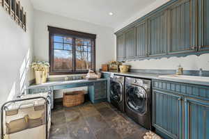 Clothes washing area featuring cabinets, separate washer and dryer, and sink