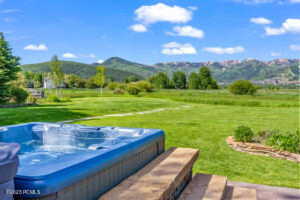 View of yard with an outdoor hot tub and a mountain view