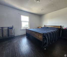 Bedroom featuring dark wood-type flooring and a textured ceiling