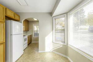 Kitchen featuring white appliances and light carpet