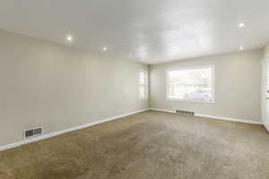 Empty room with carpet floors and a textured ceiling