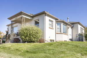 View of side of home featuring a lawn