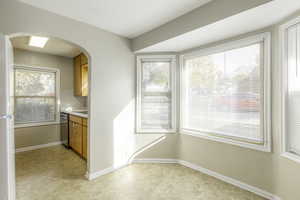 Kitchen featuring light carpet and stainless steel dishwasher