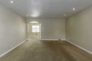 Carpeted spare room with a textured ceiling