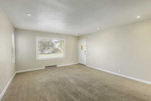 Carpeted spare room with a textured ceiling