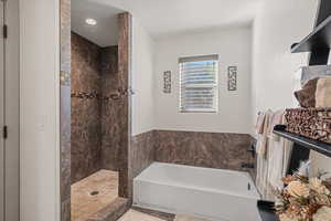 Bathroom featuring a textured ceiling and separate shower and tub