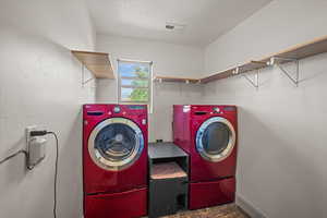 Clothes washing area with a textured ceiling and separate washer and dryer