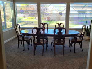 Carpeted formal dining area featuring plenty of natural light, lofted ceiling, and ceiling fan