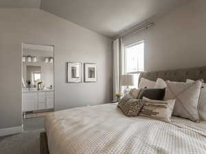 Carpeted bedroom with ensuite bathroom, lofted ceiling, and a textured ceiling