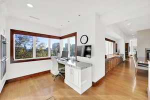 Office space with light hardwood / wood-style flooring and built-in desk with stunning views to the south and the west.