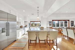 Kitchen featuring white cabinets, stainless steel appliances, pendant lighting, and a kitchen island