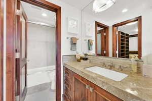 Bedroom 2 ensuite - Full bathroom with vanity, travertine tile floors, combined bath / shower with glass door, and toilet