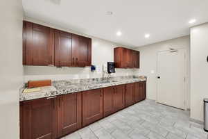 Common Area Social Room Kitchen with sink and light stone countertops