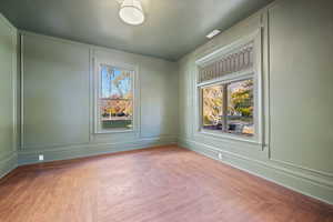 Empty room with light parquet floors and a wealth of natural light