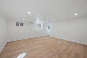 Empty room featuring a wall mounted AC and light hardwood / wood-style flooring