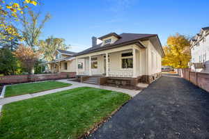 View of front facade featuring a front yard and covered porch