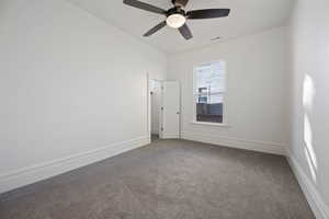 Carpeted spare room featuring ceiling fan