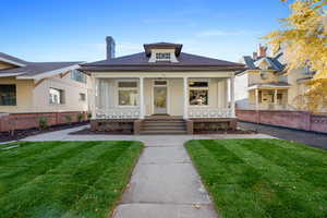 Bungalow featuring a front lawn and covered porch