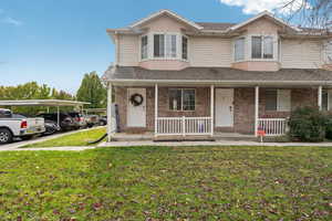 View of front of property with a front yard and a carport