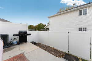 Backyard view of patio with grilling area and cooling unit