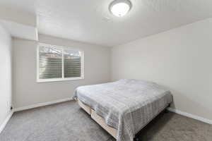 Bedroom with a textured ceiling and carpet flooring