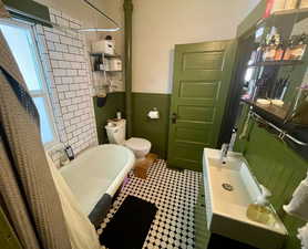 Bathroom featuring toilet and shower / bathtub combination with curtain