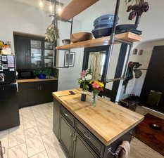 Kitchen with wooden counters, black appliances, and a kitchen island