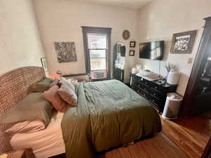 Bedroom with hardwood / wood-style floors and cooling unit