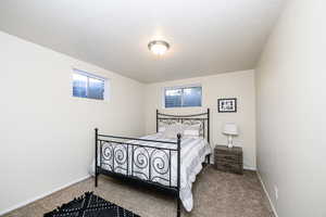 Bedroom with a textured ceiling and carpet flooring