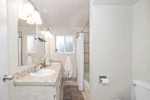 Full bathroom featuring vanity, shower / tub combo with curtain, tile patterned flooring, and toilet