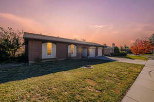 Ranch-style home featuring a garage and a lawn